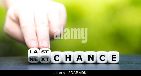 Hand dreht Würfel und ändert den Ausdruck 'Next Chance' in 'Last Chance'. Stockfoto