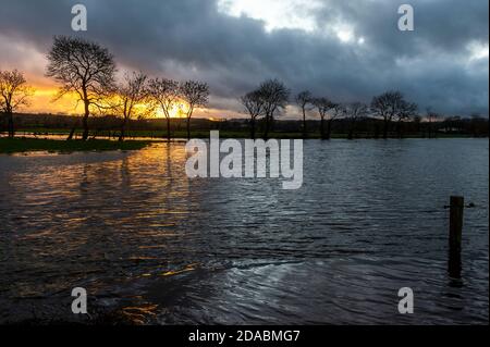 Caheragh, West Cork, Irland. November 2020. Die Sonne geht über überfluteten Feldern in Caheragh, nahe Skibbereen, nach einem Tag sintflutartigen Regens unter. Die Überschwemmung kommt inmitten einer Met Éireann gelben Wetterwarnung für die Grafschaft Cork, die bis heute Abend um 18 Uhr stattfindet. Quelle: AG News/Alamy Live News Stockfoto