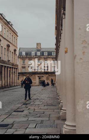 Bath, Großbritannien - 04. Oktober 2020: Mann in Gesichtsmaske mit Telefon stehend auf Bath Straße in Bath, der größten Stadt in der Grafschaft Somerset bekannt für und na Stockfoto