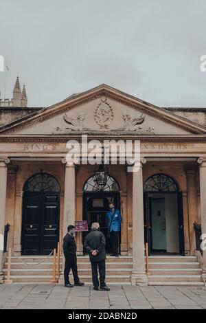 Bath, Großbritannien - 04. Oktober 2020: Mitarbeiter in Gesichtsmasken stehen am Eingang zu Kings and Queens Baths, einer gut erhaltenen römischen Badestelle. Stockfoto