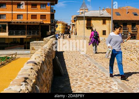 Brücke von Paso Honroso und im Hintergrund die Stadt Hospital de Órbigo. Französischer Weg, Jakobsweg. Puente de Órbigo, Hospital de Órbigo, León Stockfoto