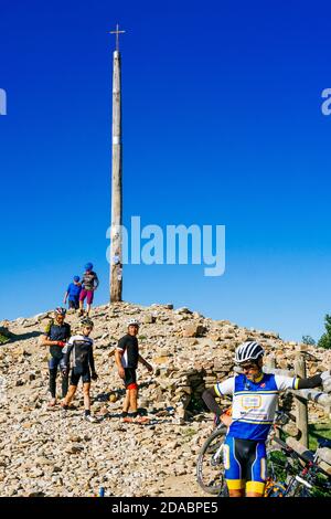 Pilger auf dem Fahrrad am Eisernen Kreuz La Cruz de Hierro. Französischer Weg, Jakobsweg. Foncebadón, León, Kastilien und Leon, Spanien, Europa Stockfoto