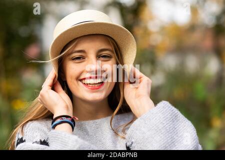 Junge Frau mit blonden Haaren und Hut in einem urbanic Garten Stockfoto