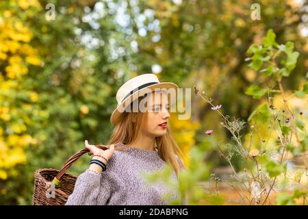 Junge Frau mit blonden Haaren und Hut in einem urbanic Garten Stockfoto