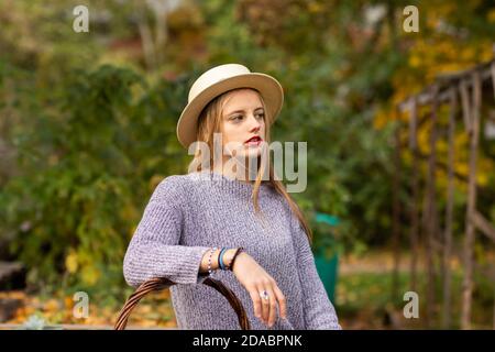 Junge Frau mit blonden Haaren und Hut in einem urbanic Garten Stockfoto