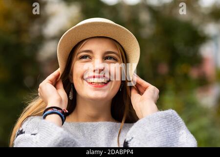 Junge Frau mit blonden Haaren und Hut in einem urbanic Garten Stockfoto