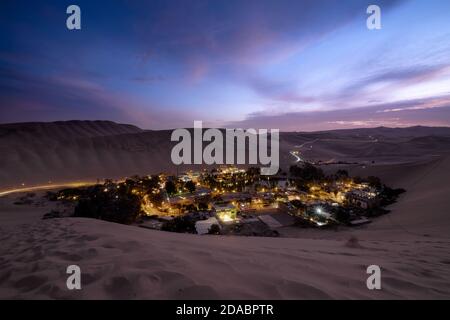 Oase Huacachina in der Abenddämmerung, ganz in der Nähe von Ica, zwischen Sanddünen Stockfoto