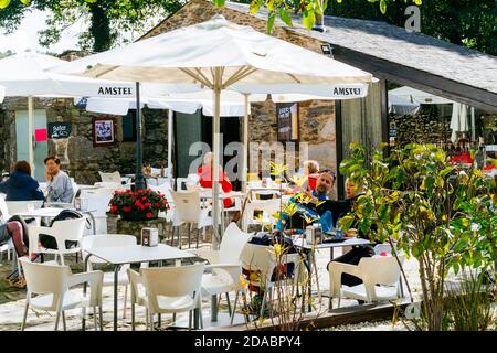 Pilger ruhen und essen auf der Terrasse des Hostel-Restaurant Mercadoiro. Französischer Weg, Jakobsweg. Mercadoiro, Laxe, Concello de Paradela, Lugo, Galic Stockfoto