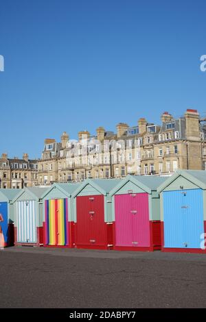 Bunte Strandhütten und Pride Strandhütte entlang der Promenade von Hove Seafront, Brighton & Hove, East Sussex, Großbritannien Stockfoto