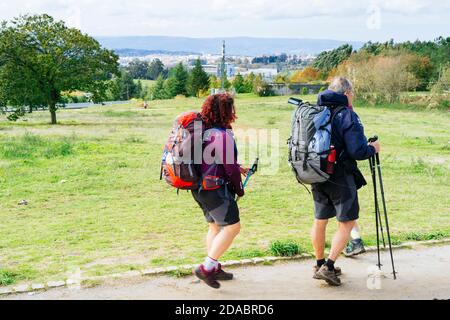 Pilgerpaar auf dem Monte del Gozo, im Hintergrund die Stadt Santiago de Compostela. Französischer Weg, Jakobsweg. Santiago de Compostela, Stockfoto