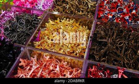 Paris, France - 09/08/2019: Metallminiaturen des Eiffelturms in verschiedenen Farben, die als Schlüsselring verwendet werden, der an Touristen als Andenken in einem Geschenkeladen verkauft wird. Stockfoto