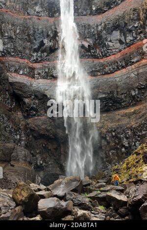 Hengifoss Canyon mit dem Hengifoss Wasserfall ist der dritthöchste Wasserfall Islands von basaltischen Schichten mit roten Lehmschichten umgeben Stockfoto