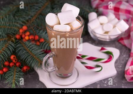 Kakao mit Marshmallows in einem hohen Glas auf dem Hintergrund der Weihnachtsdekoration. Stockfoto