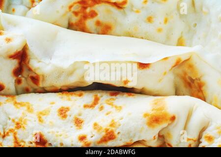 Gebratene Pfannkuchen Rollen Hintergrund. Hausgemachte Pfannkuchen mit Hüttenkäse zum Frühstück. Konzept der russischen Küche Stockfoto