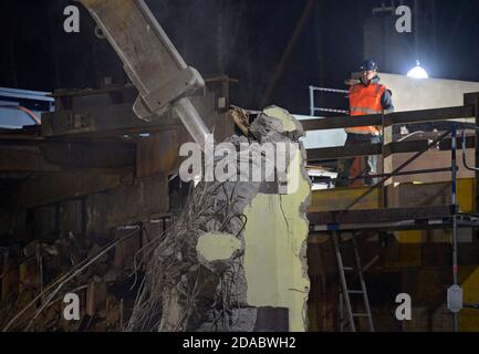 10. November 2020, Brandenburg, Birkenwerder: Baumaschinen zerquetschen und verladen die Aufbauten der ehemaligen Eisenbahnbrücke auf der Baustelle der Autobahn A10 in der Nähe der Anschlussstelle Birkenwerder. Die Nachtarbeit war in Vorbereitung für das Anheben einer rund 205 Tonnen schweren Stahlbrücke und einer rund 180 Tonnen schweren Stahlbrücke für die Eisenbahn- oder S-Bahn-Verbindung zwischen Oranienburg und Hohen-Neuendorf. Der Ersatzbau durch das Joint Venture (ARGE) Havellandautobahn GmbH ist Teil des Ausbaus der Autobahn A10 und erfordert eine vollständige Stilllegung des Motorw Stockfoto