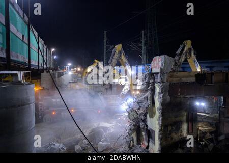 10. November 2020, Brandenburg, Birkenwerder: Baumaschinen zerquetschen und verladen die Aufbauten der ehemaligen Eisenbahnbrücke auf der Baustelle der Autobahn A10 in der Nähe der Anschlussstelle Birkenwerder. Die Nachtarbeit war in Vorbereitung für das Anheben einer Stahlbrücke mit einem Gewicht von ca. 205 Tonnen und einer Stahlbrücke mit einem Gewicht von ca. 180 Tonnen für die Eisenbahn- oder S-Bahn-Verbindung zwischen Oranienburg und Hohen-Neuendorf. Der Ersatzbau durch das Joint Venture (ARGE) Havellandautobahn GmbH ist Teil des Ausbaus der Autobahn A10 und erfordert eine vollständige Sperrung der Autobahn ab Th Stockfoto