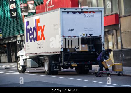 FedEx Essential Worker Pakete aus dem LKW nehmen in New York City Während Der Covid-19 Pandemie Stockfoto