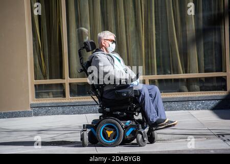 Verletzlich älterer Mann im Rollstuhl trägt Gesichtsmaske während der Covid-19 Pandemie in NYC Stockfoto
