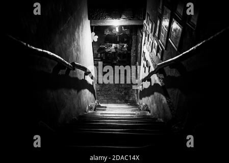 Dramatische Sicht auf die unheimlich Treppen von oben in die Dunkelheit des Inneren des alten Pubs Stockfoto