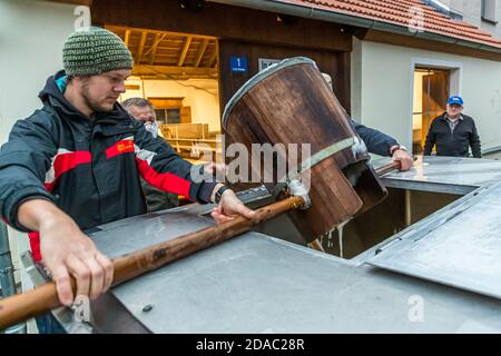 Traditionelle Zoigl Brauerei. Die Zoigl Original-Würze wird mit traditionellen Holzeimern in Falkenberg, Deutschland, lebhaft in den Tanker gefüllt Stockfoto