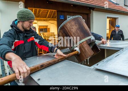 Traditionelle Zoigl Brauerei. Die Zoigl Original-Würze wird mit traditionellen Holzeimern in Falkenberg, Deutschland, lebhaft in den Tanker gefüllt Stockfoto