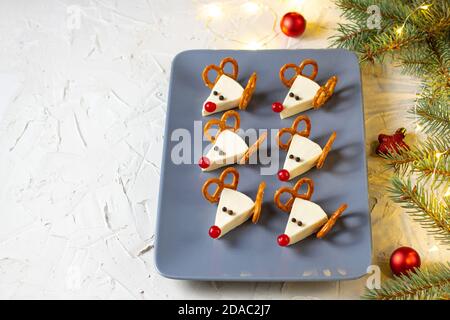 Lustige weihnachts-Snack in Form von Hirschen für Kinder Party. Konzept Neujahrskost aus Käse und Brezeln auf weißem Hintergrund Stockfoto