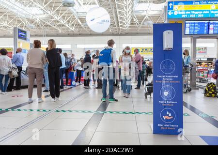 Antalya, Türkei-circa Oct, 2020: Antibakterielle Desinfektionsmittel ist in intarnational Flughafen-Terminal. Ein Hinweisbrett mit Regeln fordert die Leute auf, ein soziales di zu halten Stockfoto