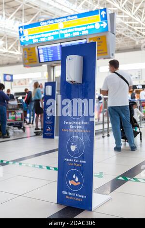 Antalya, Türkei-circa Okt, 2020: Spender mit antibakteriellem Gel ist im Antalya International Airport. Schilder mit Benachrichtigung über das Halten von Socia Stockfoto