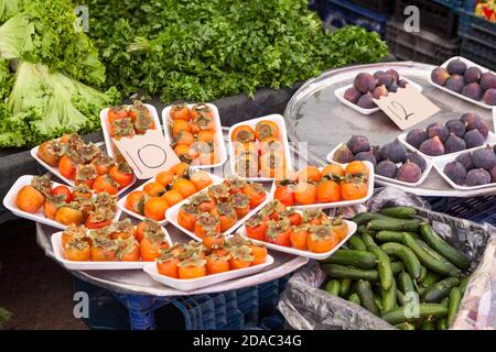 Kaki und violette Feigenfrüchte sind auf Kunststoffkisten. Obst- und Gemüsemarkt ist in Alanya, Türkei Stockfoto