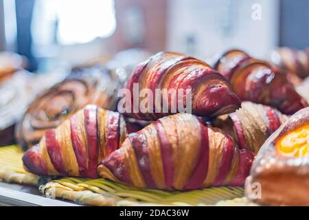 Auswahl an frisch gebackenen Croissants zum Verkauf an der Theke von Geschäft, Markt, Café oder Bäckerei - Nahaufnahme. Dessert, Gebäck, Frühstück, süße Speisen und Stockfoto