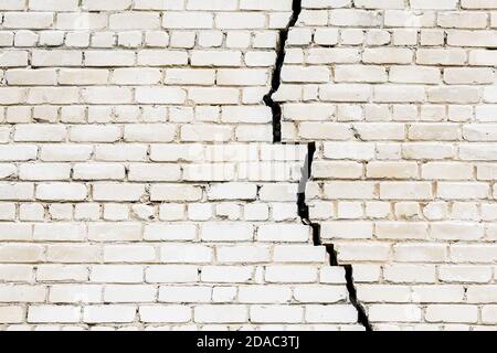 Ein großer langer und breiter Riss in einem weißen Ziegel Wand Stockfoto