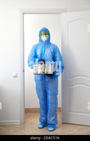 Unkenntlich medizinischer Wissenschaftler in schützenden Uniform Türen öffnen und betreten Laborraum mit Metallkoffer und Proben Stockfoto
