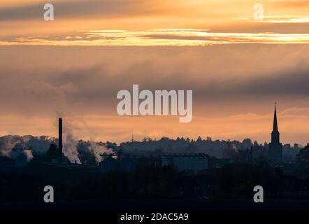 Skyline bei Sonnenuntergang mit Haddington Town Hall Spire und Pure Malt Factory Silhouetten, East Lothian, Schottland, Großbritannien Stockfoto