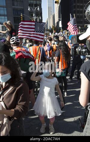Die Menschen feiern Joe Bidens Sieg des Präsidenten in New York City, die mit überwältigender Mehrheit demokratisch stimmt. Columbus Circle am Morgen der Ankündigung, 7. November. Stockfoto