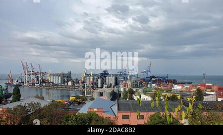 Hafenhafen mit Getreideaufzug Terminal und Container-Bereich. Industrieller Blick auf das Meer unter stürmischen Wolken in hohem Himmel. Maritime Hafenlandschaft im Hafen von Stockfoto