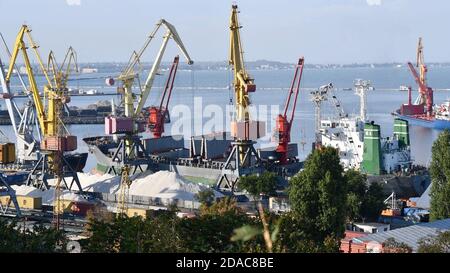 Bulk-Carrier-Schiff unter Ladung von Klinker Ladung Verladung durch Landkrane mit Greifern. Bulk-Cargo-Terminal des Seehafens. Logistik Industrie Backgroun Stockfoto