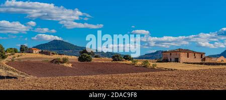 Panoramablick über die Landschaft mit Feldern, blauem Himmel, schönen Wolken, alten verlassenen Bauernhof, La Mancha, Spanien Stockfoto