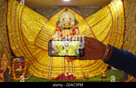 Beawar, Rajasthan, Indien, 11. November 2020: Ein Anhänger klickt auf das Bild des Hindu-gottes Khatu Shyam anlässlich von Rama Ekadashi in Beawar. Weltberühmter Tempel Khatu Shyam befindet sich in Sikar Bezirk in Rajasthan, heute nach einer langen Lücke von 236 Tagen inmitten Coronavirus Pandemie wieder geöffnet. Shyam ist die Form von Lord Krishna. Kredit: Sumit Saraswat/Alamy Live Nachrichten Stockfoto