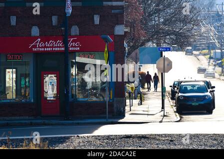 Ein Paar, das Hand in Hand in der Nähe des Tattoo-Salons Montpelier, der Hauptstadt von Vermont, USA, spazieren geht. Stockfoto