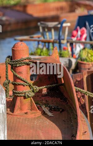 Ein rostrotes altes, schmales Boot beugt sich am Grand Union Kanal bei Braunston links, um auf dem Treidelpfad zu verfaulen. Stockfoto