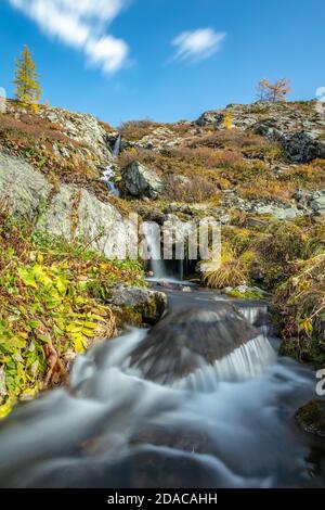 Schöne Low-Angle-Aufnahme von Wasserfall in Altai-Bergen in Sibirien, Russland. Karakolskie Seen. Glattes, seidiges Wasser und Wolken. Blauer Himmel mit Wolken A Stockfoto