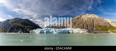 Panoramablick auf den Margerie-Gletscher, umgeben von riesigen Bergen im Glacier Bay National Park und Preserve, Alaska, USA. Schneebedeckte Berggipfel Stockfoto