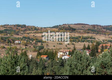 Schöne Landschaft im Herbst bulgarischen Bergdorf Bäume blauen Himmel Hintergrund am Hang Stockfoto