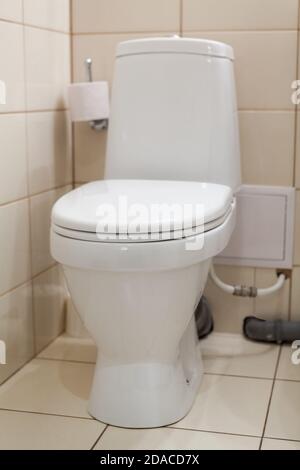 Saubere weiße Toilette im Badezimmer mit geschlossenem Deckel, eine Vorderansicht Stockfoto