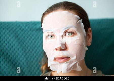 Verjüngende Maske, die eng an Kinn, Wangen, Stirn und Nase um Mund und grüne Augen, weibliches Gesicht während der Hautpflege passt Stockfoto