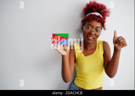 Afrikanische Frau mit afro Haar, tragen gelbe Singlet und Brillen, halten Eritrea Flagge isoliert auf weißem Hintergrund, zeigen Daumen nach oben. Stockfoto