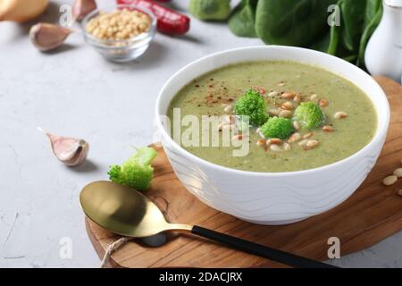 Vegetarische Sahnesuppe mit Brokkoli, Spinat und Zucchini auf grauem Hintergrund. Nahaufnahme. Stockfoto