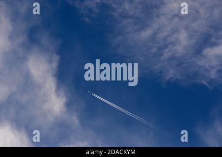 Ein Passagierflugzeug hinterlässt einen Kondensstreifen in seinem Gefolge, während es hoch über dem amerikanischen Südwesten fliegt. Stockfoto