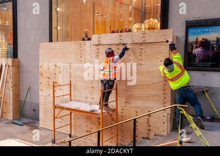 Arbeiter in Midtown Manhattan in New York am Montag, den 2. November 2020 besteigen den Kate Spade-Laden im Rockefeller Center in Erwartung möglicher Unruhen und Plünderungen nach den Wahlen am 3. November. (© Richard B. Levine) Stockfoto