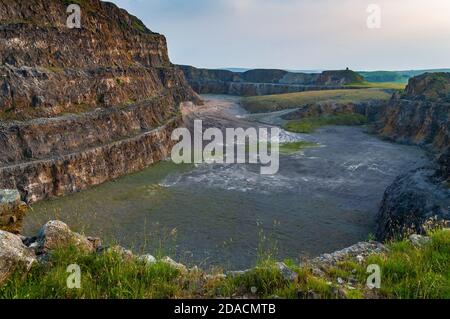 Steile Bänke aus ausgegrabenem Kalkstein im verlassenen Eldon Hill Quarry, zwischen Castleton und Peak Forest, bei Abendsonne, Blick nach Westen. Stockfoto